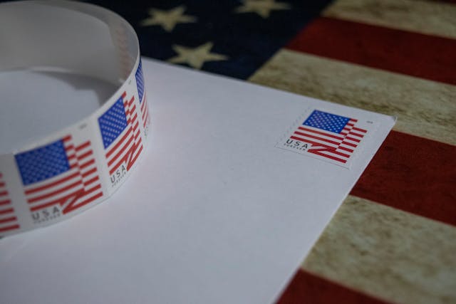 A postage stamp with the U.S. flag on an envelope.
