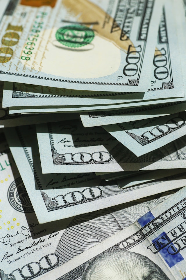 A close-up of a collection of hundred US dollar bills.