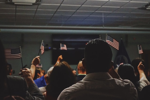 A group of people holds miniature versions of the U.S. flag.