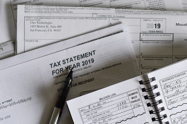 A black pen next to several tax documents.