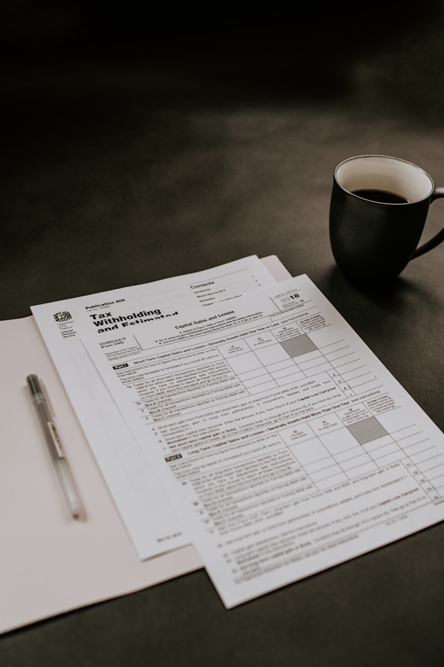 A tax document next to a pen and a cup of coffee.